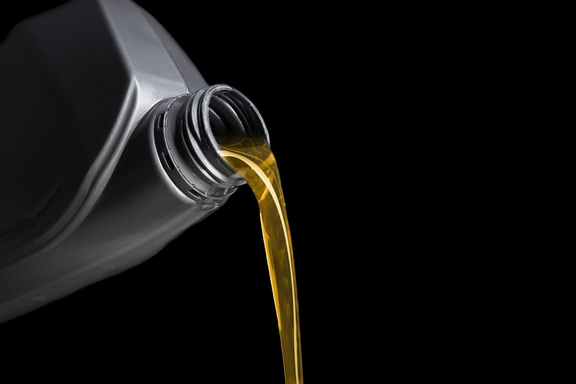 Pouring of Motor Oil from Canister against Black Background, Closeup